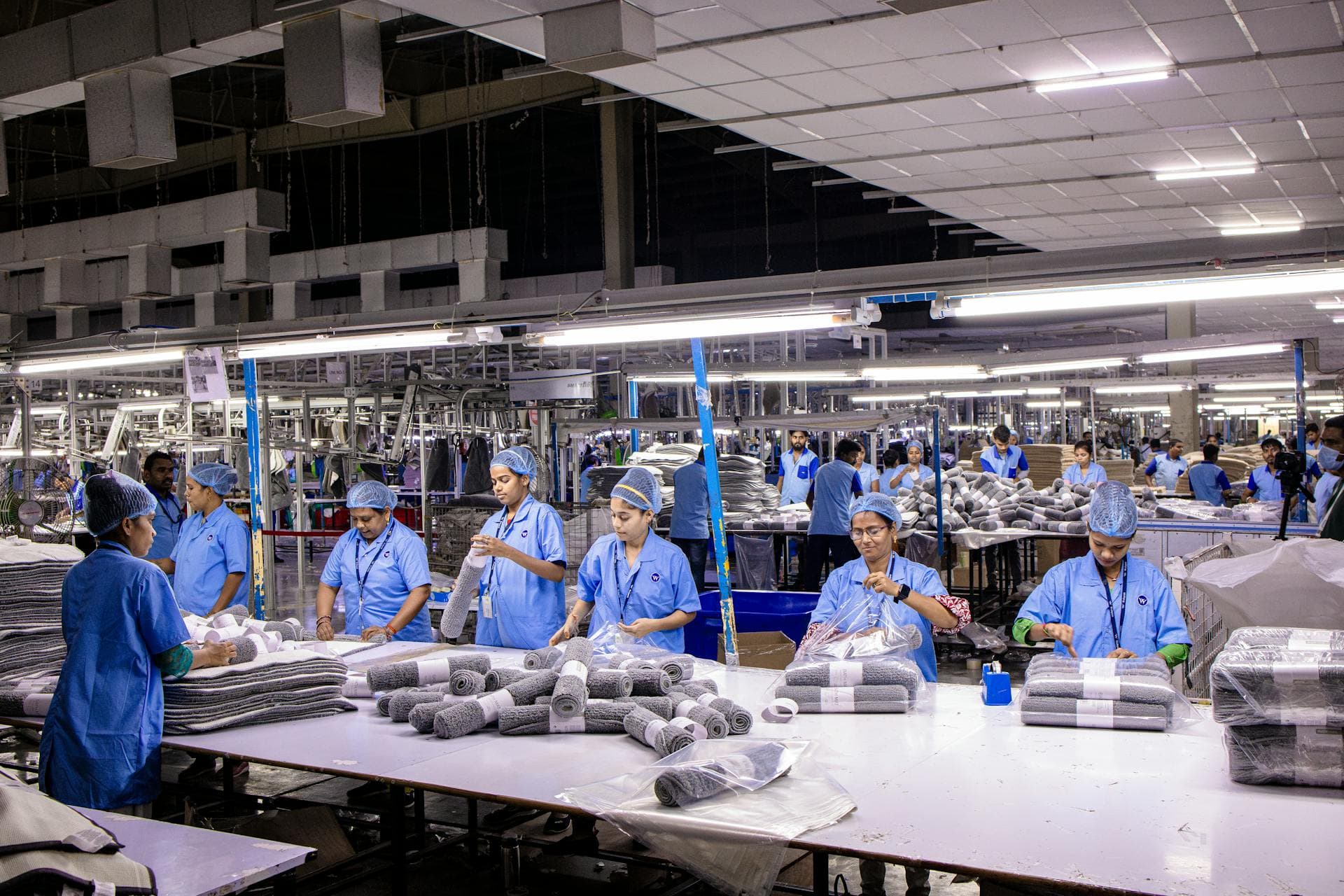 Garment factory workers packing clothes at a textile production line
